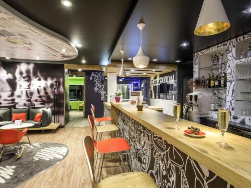ペルピニャンにあるibis Perpignan Sud Saint Charlesのレストラン(オレンジの椅子が備わるバー付)