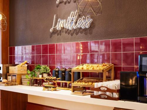 a restaurant with a counter with a sign on the wall at Novotel Bristol Centre in Bristol