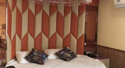 a bedroom with a bed with two pillows on it at Ease Hotel Shanghai Chuanhuan Nan Road Chuansha Metro Station in Shanghai