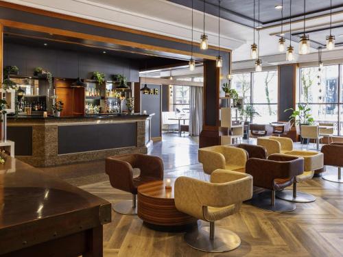 a lobby with a bar with chairs and tables at Novotel Bristol Centre in Bristol