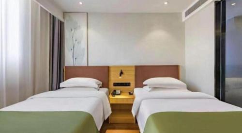 two beds in a hotel room with at GreenTree Inn Express Datong High-Speed Railway Station Old City Wall in Datong