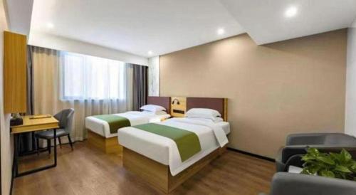 a hotel room with two beds and a desk at GreenTree Inn Express Datong High-Speed Railway Station Old City Wall in Datong