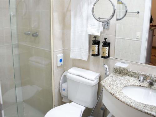 a bathroom with a toilet and a sink and a shower at Mercure Sao Caetano do Sul in São Caetano do Sul
