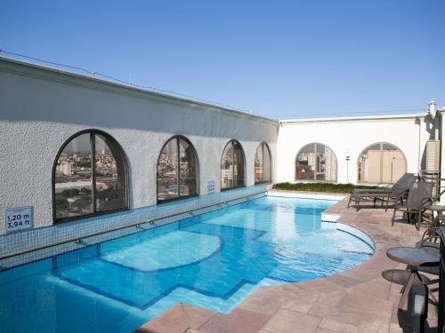 a swimming pool with blue water in a building at Mercure Sao Caetano do Sul in São Caetano do Sul