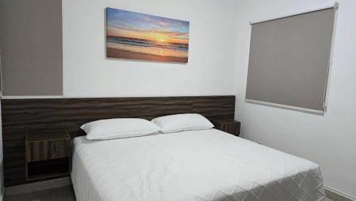 a bedroom with a white bed with two pillows at Paraíso Liverte Cancún 603 in Cancún
