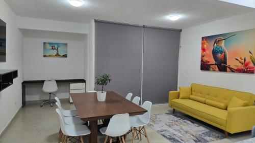 a living room with a yellow couch and a table at Paraíso Liverte Cancún 603 in Cancún