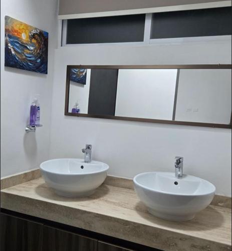 a bathroom with two white sinks on a counter at Paraíso Liverte Cancún 603 in Cancún