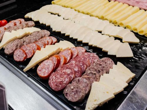 a grill with different types of meats and cheese at ibis Joinville in Joinville