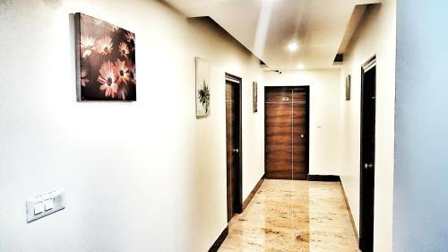 a hallway with a door and paintings on the walls at Hotel Delhi Aerocity in New Delhi