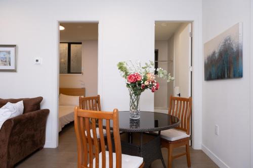 a dining room with a table with a vase of flowers at New 2BR Suite With Great Ocean View in West Vancouver in West Vancouver