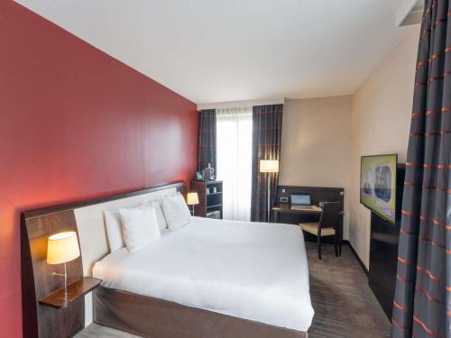 a hotel room with a bed and a desk at Mercure Le Mans Centre in Le Mans
