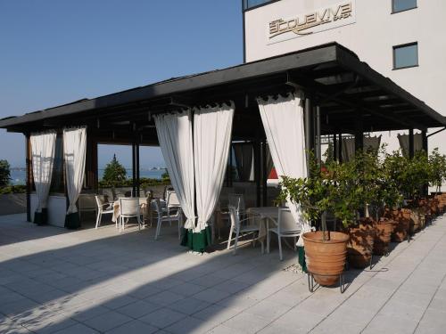 a restaurant with white curtains and tables and chairs at Hotel Acquaviva Del Garda in Desenzano del Garda