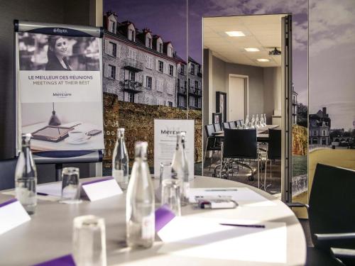 a table with bottles on it in a restaurant at Mercure Le Mans Centre in Le Mans
