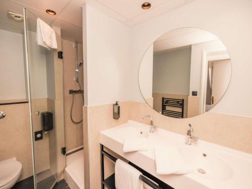 a bathroom with two sinks and a mirror at ibis Styles Deauville Villers Plage in Villers-sur-Mer