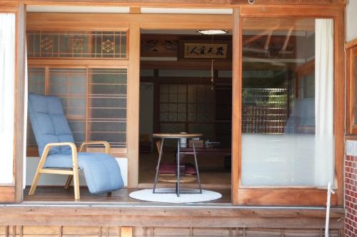 a porch with two chairs and a table and a sign at いろどり荘 in Imabari