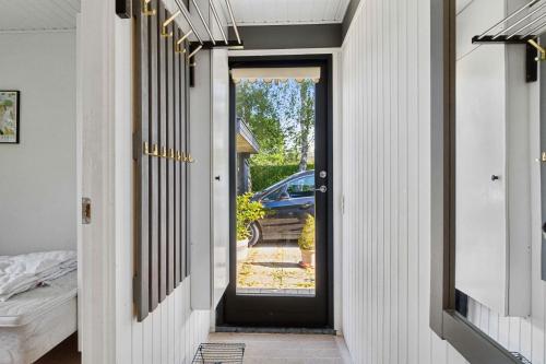 a hallway with a black door with a car outside at Holiday Paradise With Pool Near Havnsø Beach in Føllenslev