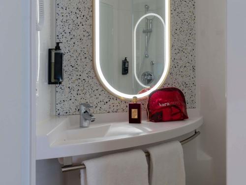 a bathroom with a white sink and a mirror at ibis Marne La Vallée Val d'Europe in Montévrain