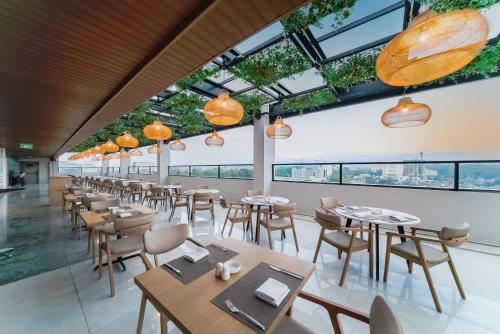 a restaurant with tables and chairs and windows at Truntum Cihampelas in Bandung