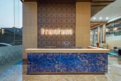 a hotel lobby with a front counter with a sign on the wall at Truntum Cihampelas in Bandung