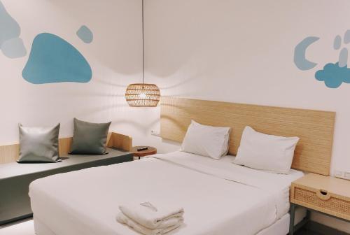 a bedroom with a large bed with white sheets and pillows at Sanctuary Hotel Slipi in Jakarta