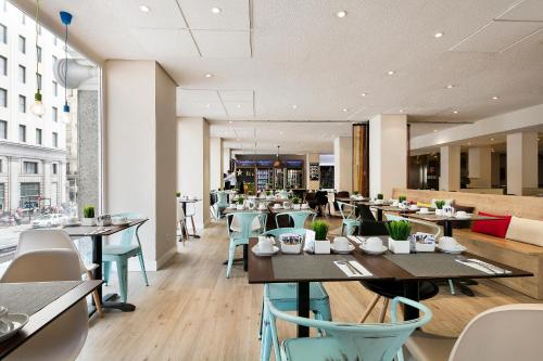 uma sala de jantar com mesas e cadeiras num restaurante em Hotel Madrid Gran Via 25, Affiliated by Meliá em Madri