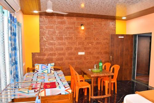 a dining room with two tables and orange chairs at Shivai holiday home in Alibaug