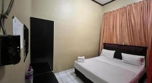 a bedroom with a white bed and a window at Sapadia Hotel Parapat in Parapat
