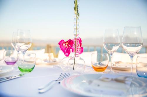 a table with wine glasses and a flower in a vase at Hotel Acquaviva Del Garda in Desenzano del Garda