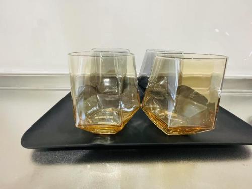 Dos vasos de whisky sobre una bandeja negra. en モリアパートメント 203, en Tokio