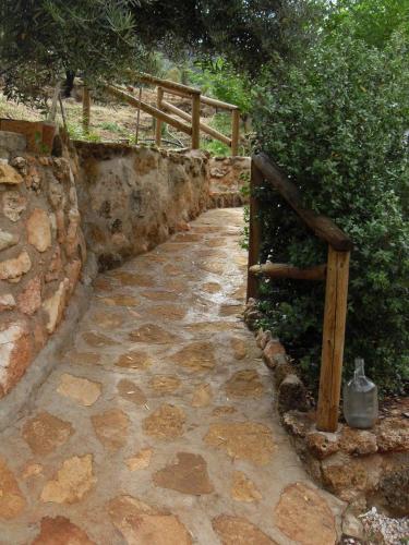 a stone walkway with a wooden gate and a fence at Cortijo el Nolo in Chincolla