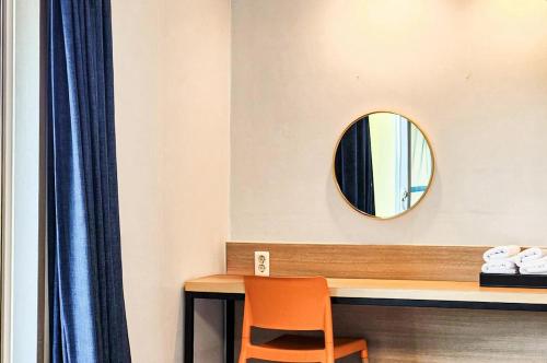 a mirror on the wall above a table with a chair at Whinstone Hotel & Resort in Jeju