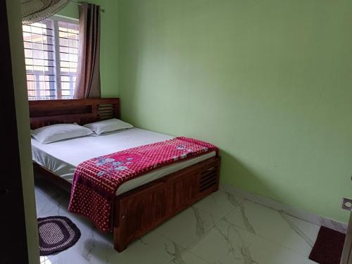 a bedroom with a bed in a green room at Sili Homestay in Madikeri