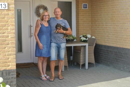 a man and a woman holding a dog on a porch at B&B Von Clermont Park in Vaals