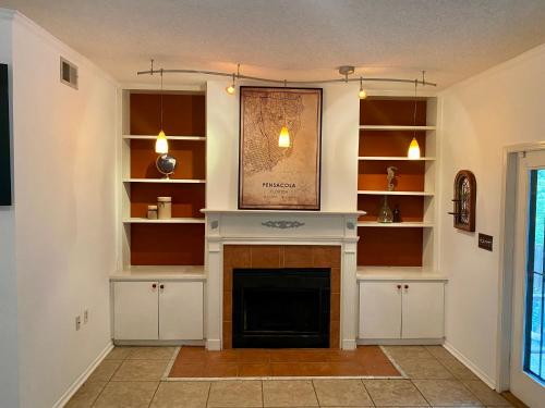 a living room with a fireplace and shelves at Willy Wonka House in Pensacola
