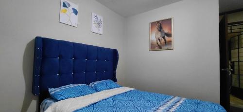 a bed with a blue headboard in a bedroom at Depa Amoblado en Villa María, Excelente ubicación, WiFi, y Parking in Villa María del Trunfo