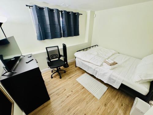 a bedroom with a bed and a desk and a chair at Comfort Stay by Stony Brook University & Hospital in Centereach
