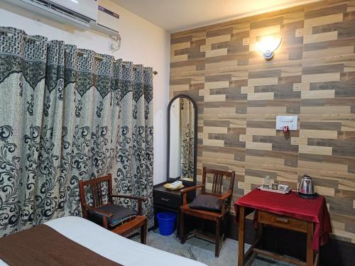 a bedroom with a bed and a table and chairs at Shiv Sakthi villa in Kumbakonam