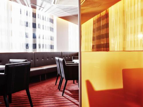 a restaurant with a table and chairs and a window at Novotel Le Havre Centre Gare in Le Havre