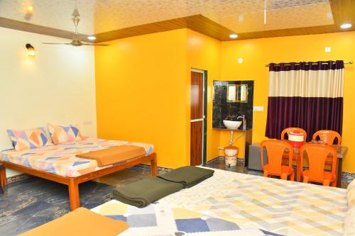 a bedroom with two beds and orange chairs at Shivai holiday home in Alibaug