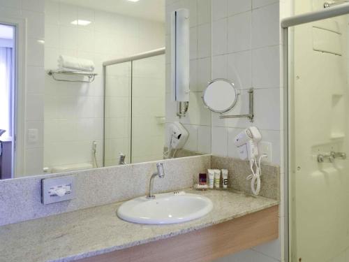 a bathroom with a sink and a mirror at Mercure Manaus in Manaus