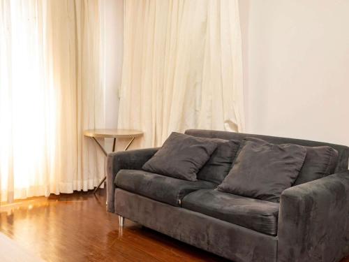 a couch sitting in a living room next to a window at Mercure Manaus in Manaus