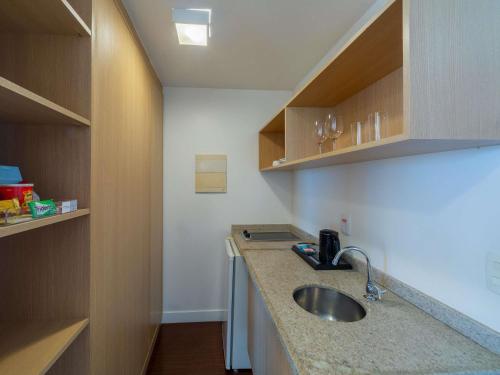 a small kitchen with a sink and a counter at Mercure Manaus in Manaus
