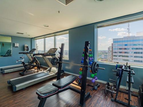 a gym with exercise equipment and a large window at Mercure Manaus in Manaus