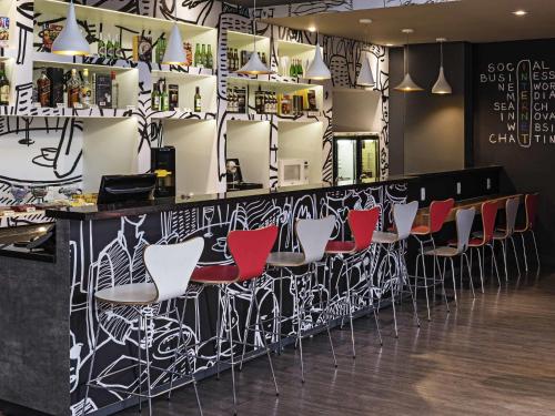 a bar with red and white bar stools at ibis Santo Andre in Santo André