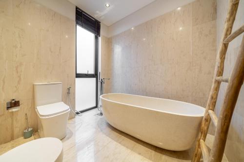 a bathroom with a large tub and a toilet at Townhouse T2 -Live Like a Local - Sophisticated Townhouse in Ubud in Ubud