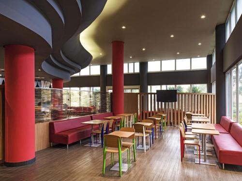 a restaurant with tables and chairs and a tv at ibis Santo Andre in Santo André