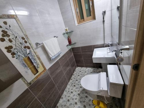 a bathroom with a toilet and a sink at 꽃이피다 in Kulchŏn