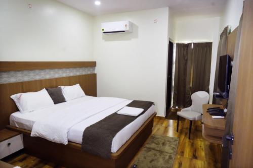 a bedroom with a bed and a television in a room at Hotel V R Grand in Bhadrāchalam