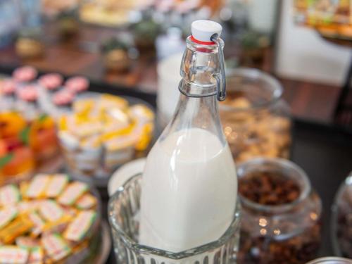 a bottle of milk sitting on a table with pastries at Hotel Plaza Biarritz Plage - Handwritten Collection in Biarritz