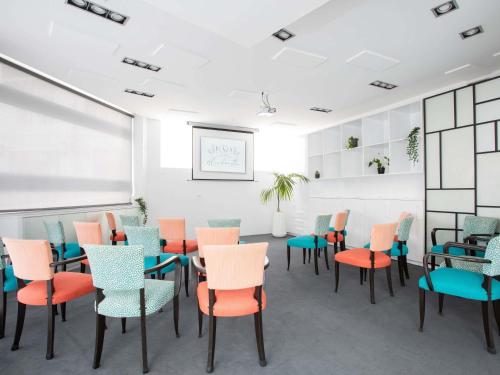 a waiting room with colorful chairs and tables at Hotel Plaza Biarritz Plage - Handwritten Collection in Biarritz